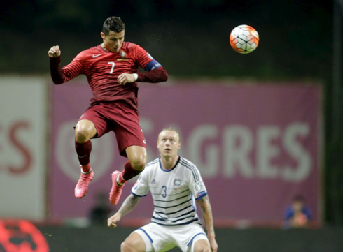 Cristiano Ronaldo rising high in the air to head a ball, while wearing the Portuguese uniform