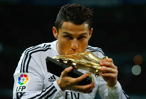 Cristiano Ronaldo kissing the Golden Shoe he recently won, at the Santiago Bernabéu