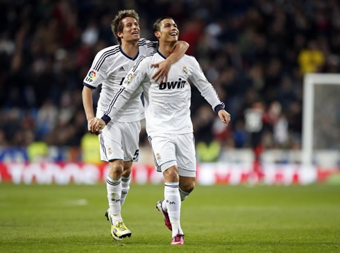 Cristiano Ronaldo being hugged by Fábio Coentrão, as they look towards the Santiago Bernabéu stands, in La Liga 2013