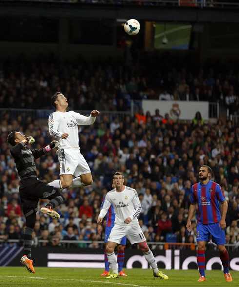 Cristiano Ronaldo rises above a goalkeeper to head the ball, in a match for Real Madrid