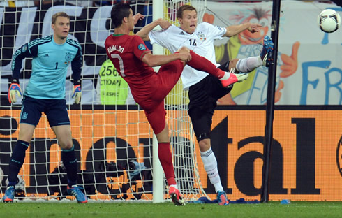 Cristiano Ronaldo and Badstuber raising their foot to challenge a loose ball, in the EURO 2012