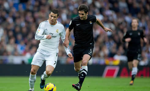 Cristiano Ronaldo being pulled by his arm in a run side by side with a Real Sociedad defender