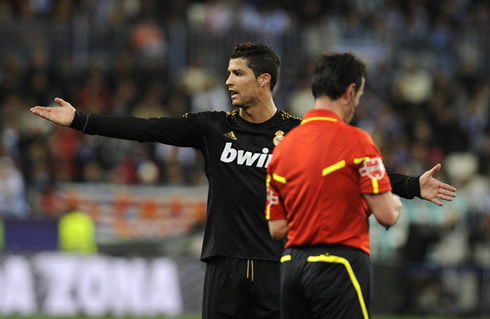 Cristiano Ronaldo gestures in front of the referee, opening his arms in protest