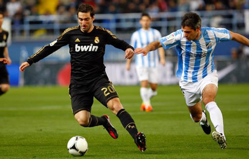 Gonzalo Higuaín runs with the ball but gets chased by Toulalan, in Malaga vs Real Madrid, in 2012