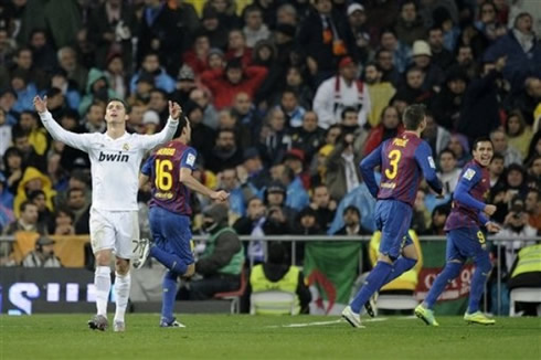 Cristiano Ronaldo raising his hands, while Barcelona players celebrate a goal in the Santiago Bernabéu, during the Clasico 2011-2012