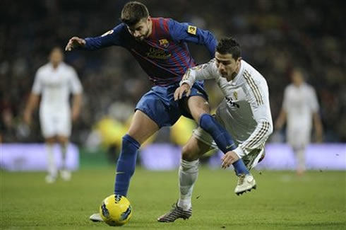Cristiano Ronaldo goes to the ground after disputing the ball with Gerard Piqué in the Clasico between Real Madrid and Barcelona