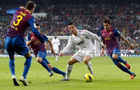 Cristiano Ronaldo running with the ball with Piqué, Xavi and Daniel Alves near him when Real Madrid hosted Barcelona in the Santiago Bernabéu