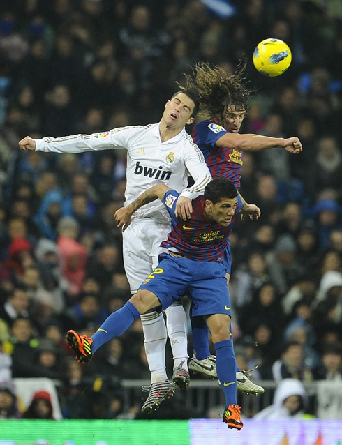 Cristiano Ronaldo jumping with Carles Puyol and Daniel Alves, in Real Madrid vs Barcelona