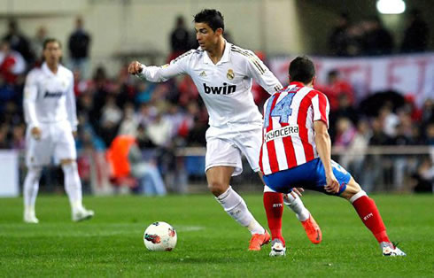 Cristiano Ronaldo dribbling an Atletico Madrid defender in the Madrid derby