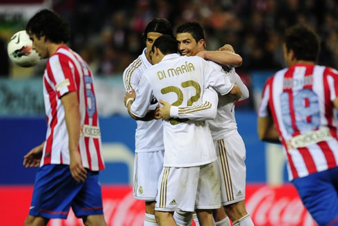 Cristiano Ronaldo hugging Khedira and Di María, but smiling to the cameras on his side