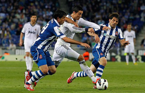 Cristiano Ronaldo holding the pushing and shoving from Espanyol defenders, in a game for Real Madrid in 2013