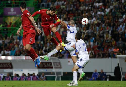 Cristiano Ronaldo jumping high in the air to head a ball coming in from a cross, in Portugal vs Israel