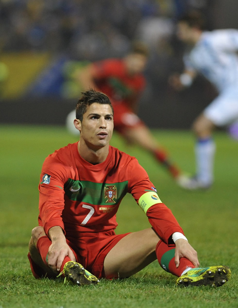 Cristiano Ronaldo seated on the turf, looking at the Bosnian crowd