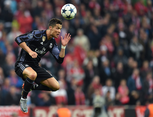 Cristiano Ronaldo heads the ball in the air in a Champions League night game