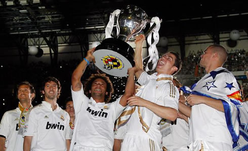 Cristiano Ronaldo and Marcelo raising and lifting the Spanish League (La Liga) trophy really high, at the Santiago Bernabéu, in 2012