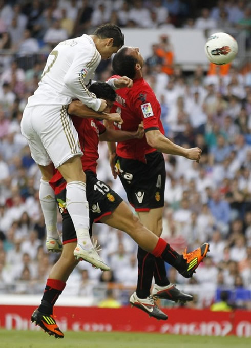 Cristiano Ronaldo heading the ball on the back of two defenders from Mallorca