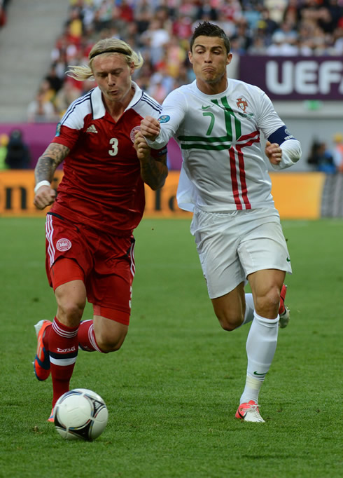 Cristiano Ronaldo shoulder charging a Danish defender in the EURO 2012