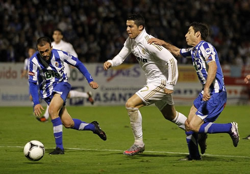 Cristiano Ronaldo sprints between two defenders in a Real Madrid game for the Copal del Rey, in 2011-2012