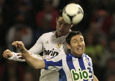 Cristiano Ronaldo jumps higher than a defender, to head the ball