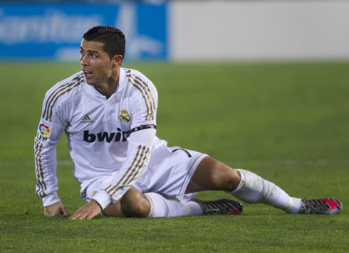 Cristiano Ronaldo sitted on the ground and looking sideways