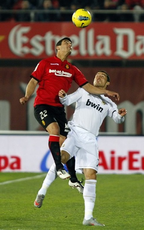 Cristiano Ronaldo chooses not to jump, while a defender tries to head the ball