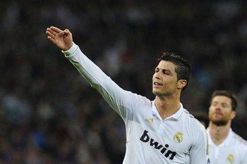 Cristiano Ronaldo stretches his right arm while pointing at something far away