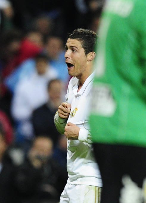 Cristiano Ronaldo funny face when celebrating goal for Real Madrid and showing his love by pointing to the club's badge