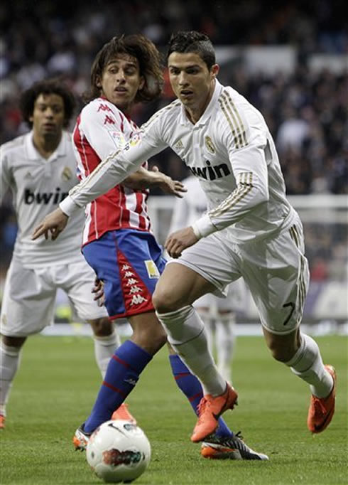 Cristiano Ronaldo getting past a defender in Real Madrid vs Sporting Gijon, in 2012