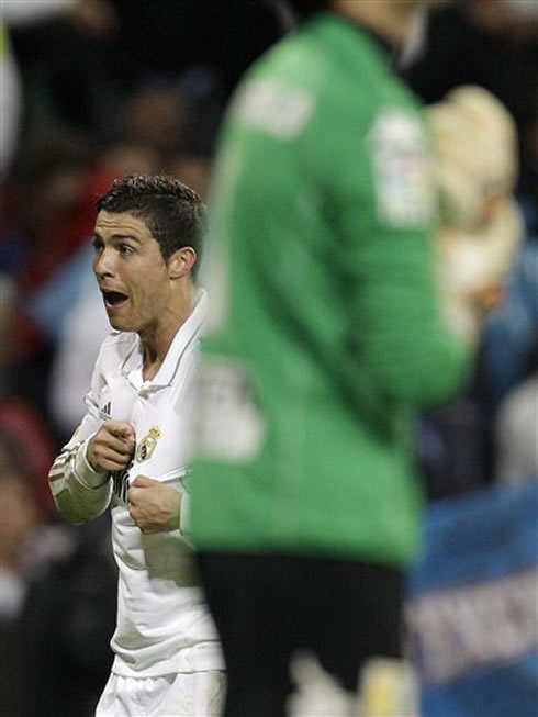 Cristiano Ronaldo smiling to Real Madrid fans, without showing his teeth and using his finger to point to Real Madrid badge and symbol, in 2012