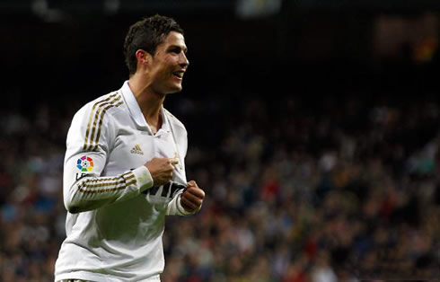 Cristiano Ronaldo showing his Madridismo by pointing to Real Madrid symbol and badge, after scoring a goal against Sporting Gijon, in La Liga 2012