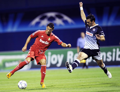 Cristiano Ronaldo dribbling an opponent in the Champions League, wearing the new Real Madrid red shirt 2011-12