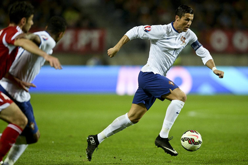 Cristiano Ronaldo running with the ball close to his right foot, in Portugal vs Armenia