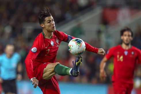 Cristiano Ronaldo stretching his right leg to control the ball