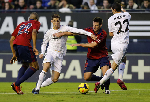 Cristiano Ronaldo trying to get past two Osasuna defenders, with Di María stepping out of his way