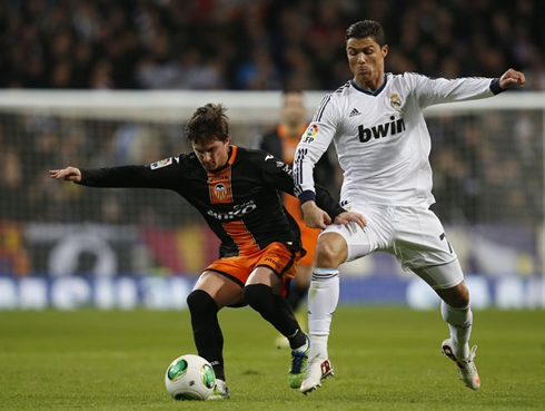 Cristiano Ronaldo fighting for the ball against Pablo Piatti, in Real Madrid vs Valencia in 2013