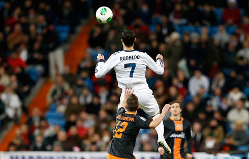 Cristiano Ronaldo jumping high in the air to control a soccer ball on his chest, in Real Madrid vs Valencia for the Copa del Rey 2013