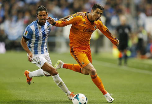 Cristiano Ronaldo running past a Malaga defender, in a Real Madrid game in La Liga
