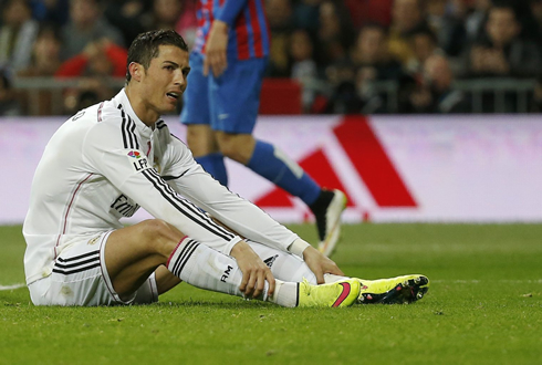 Cristiano Ronaldo sits down on the pitch and holds on to his own ankles