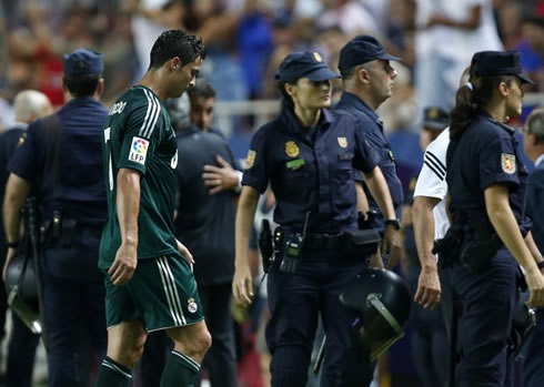 Cristiano Ronaldo walking away near a lot of female police officers, after a Real Madrid game in the Spanish League 2012/2013