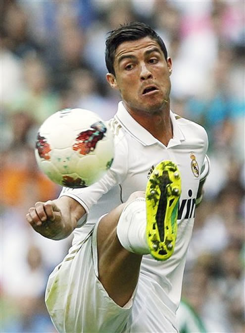 Cristiano Ronaldo raises his right leg very high to control and dominate the ball
