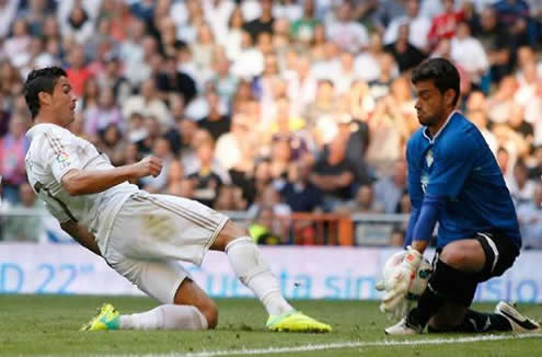 Cristiano Ronaldo stretches to attempt to reach the ball before the goalkeeper, but he arrives late