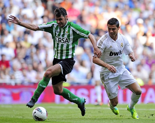 Cristiano Ronaldo being kept away from the ball, after he gets hold by a Betis defender