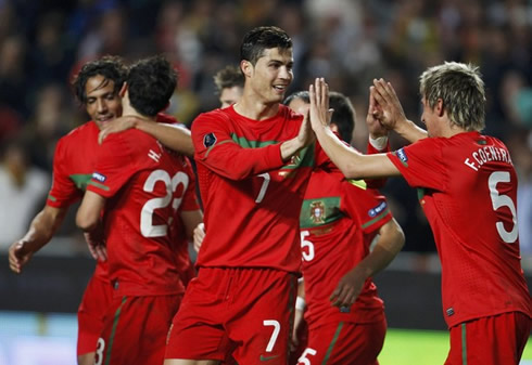 Cristiano Ronaldo touching hands with Fábio Coentrão, while Bruno Alves hugs Hélder Postiga