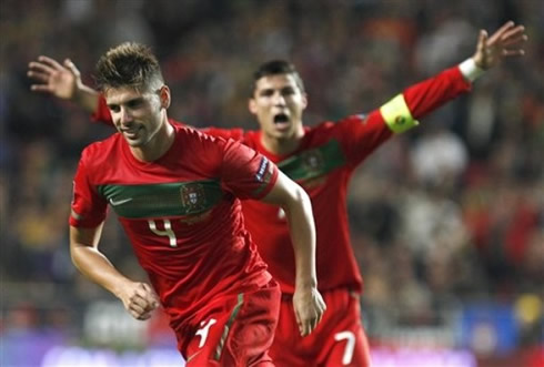 Miguel Veloso running to celebrate his free-kick goal, while Cristiano Ronaldo goes after him
