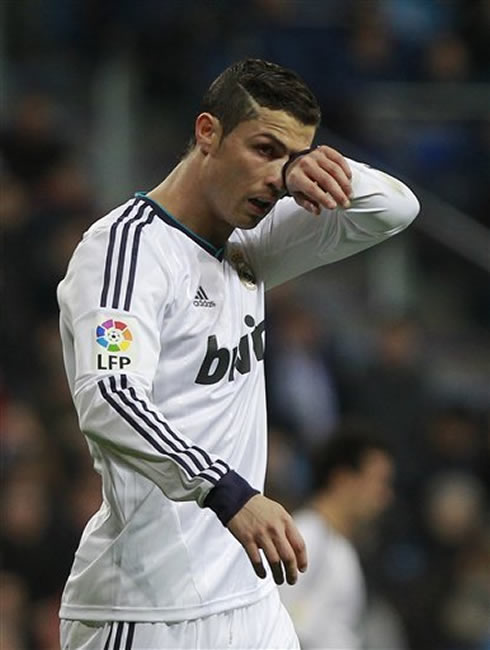 Cristiano Ronaldo wiping something from his eye, during a Real Madrid match for La Liga in 2013