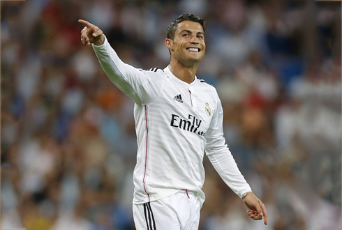 Cristiano Ronaldo points to someone as he smiles during a game