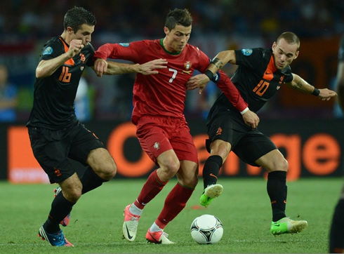 Cristiano Ronaldo trying to protect the ball as Wesley Sneijder and Robin van Persie try to steal it from him, in the EURO 2012
