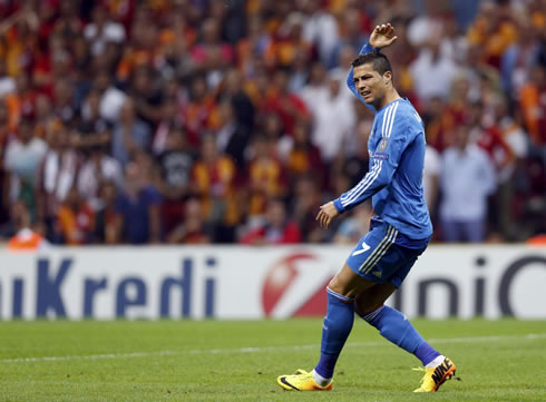 Cristiano Ronaldo raising his arm as he complains with a teammate for not having passed him the ball