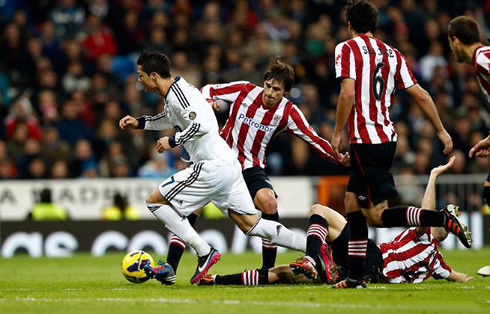 Cristiano Ronaldo being tackled as he gets past several Athletic Bilbao defenders in a game for Real Madrid, in La Liga 2012-2013