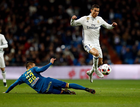 Cristiano Ronaldo jumping over an opponent on the ground